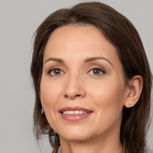 Joyful white adult female with medium  brown hair and brown eyes