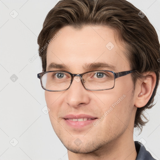 Joyful white young-adult male with short  brown hair and grey eyes