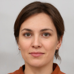 Joyful white young-adult female with medium  brown hair and grey eyes