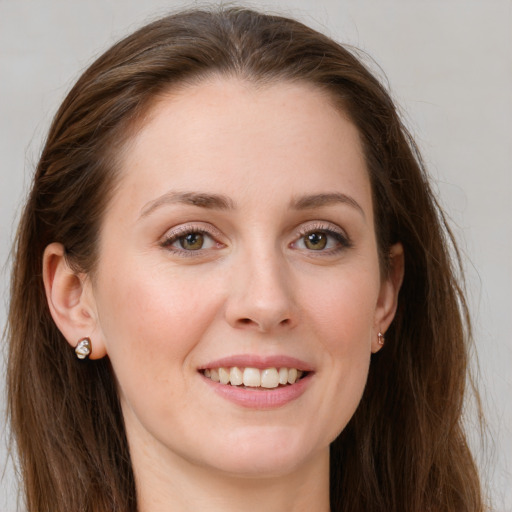 Joyful white young-adult female with long  brown hair and green eyes