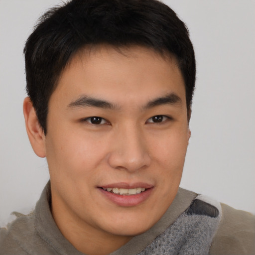 Joyful asian young-adult male with short  brown hair and brown eyes