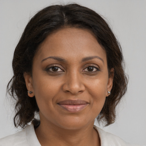 Joyful black adult female with medium  brown hair and brown eyes