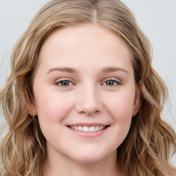 Joyful white young-adult female with long  brown hair and blue eyes