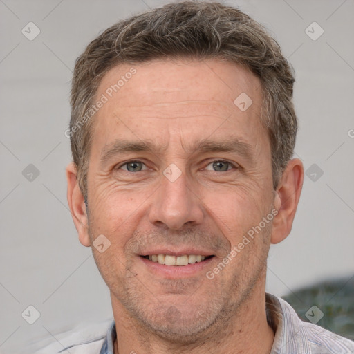 Joyful white adult male with short  brown hair and grey eyes