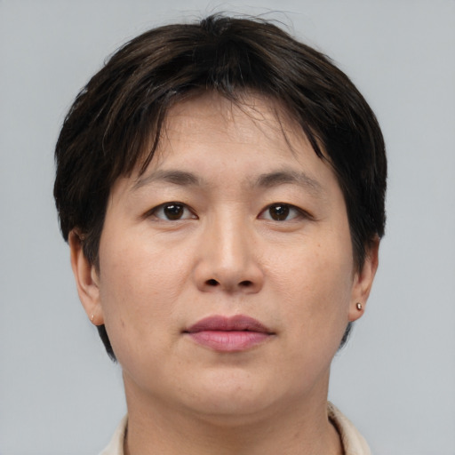 Joyful asian adult female with short  brown hair and brown eyes