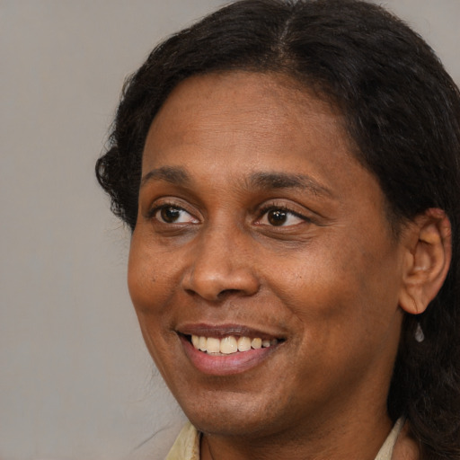 Joyful black adult female with short  brown hair and brown eyes