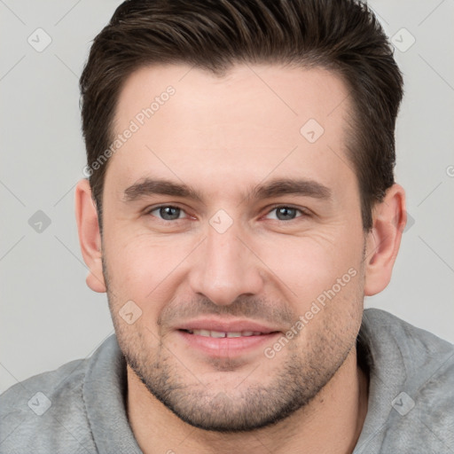 Joyful white young-adult male with short  brown hair and brown eyes