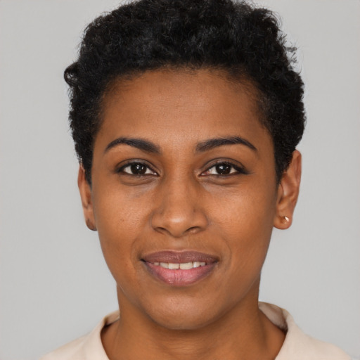 Joyful black young-adult female with short  black hair and brown eyes
