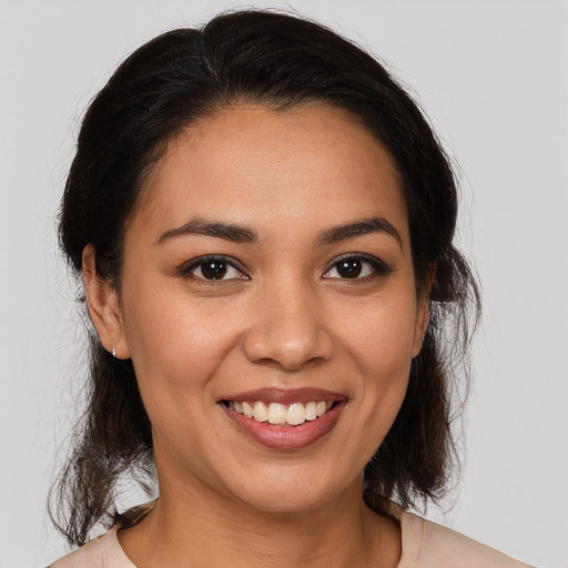 Joyful latino young-adult female with medium  brown hair and brown eyes