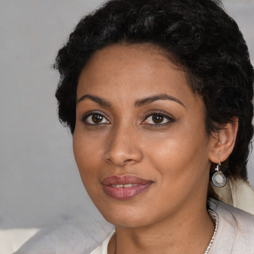 Joyful black adult female with short  black hair and brown eyes