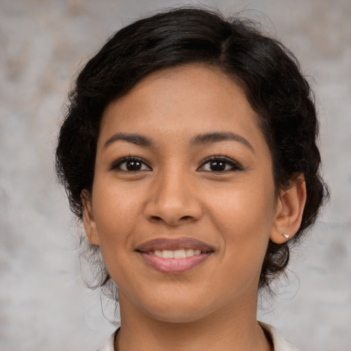 Joyful latino young-adult female with medium  brown hair and brown eyes