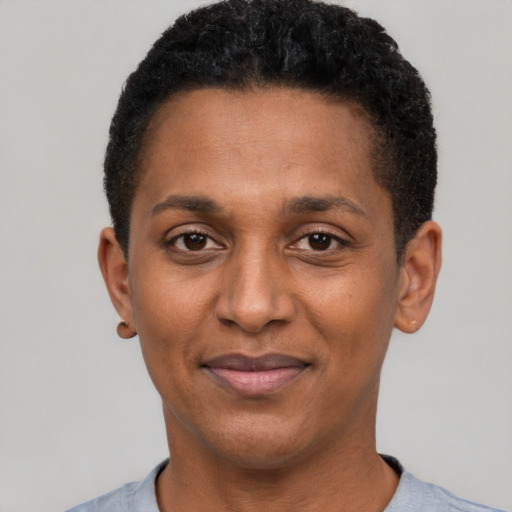 Joyful black adult male with short  black hair and brown eyes