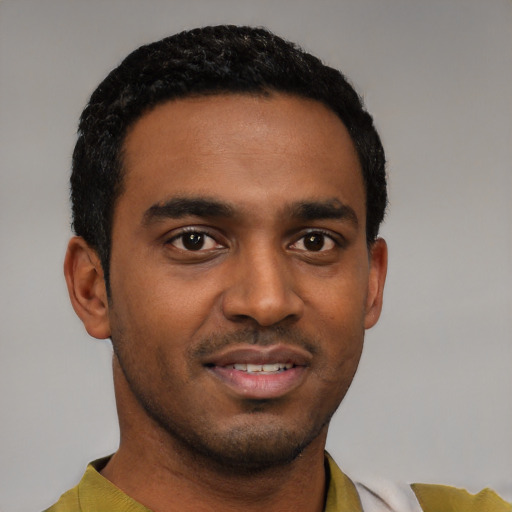 Joyful black young-adult male with short  black hair and brown eyes