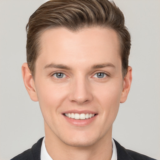 Joyful white young-adult male with short  brown hair and grey eyes