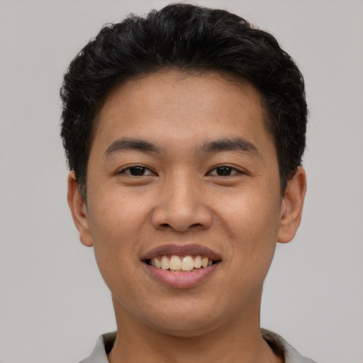 Joyful asian young-adult male with short  black hair and brown eyes