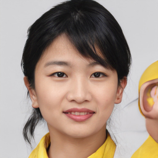 Joyful asian young-adult female with medium  black hair and brown eyes