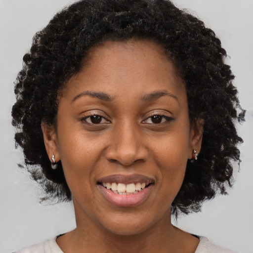 Joyful black young-adult female with short  brown hair and brown eyes