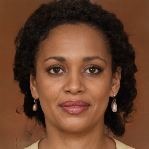 Joyful black young-adult female with long  brown hair and brown eyes