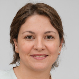 Joyful white adult female with medium  brown hair and brown eyes