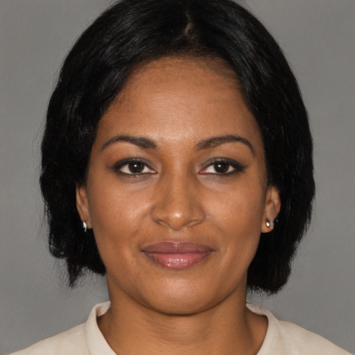 Joyful black adult female with medium  brown hair and brown eyes
