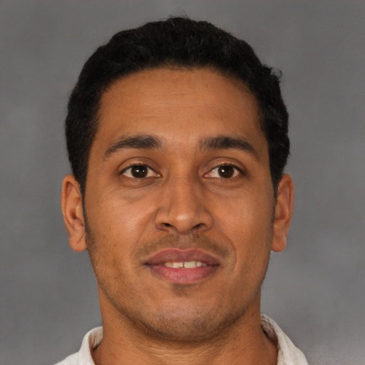 Joyful latino young-adult male with short  brown hair and brown eyes