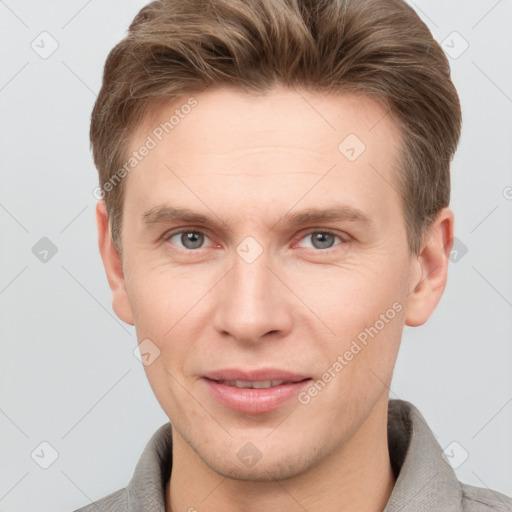 Joyful white young-adult male with short  brown hair and grey eyes