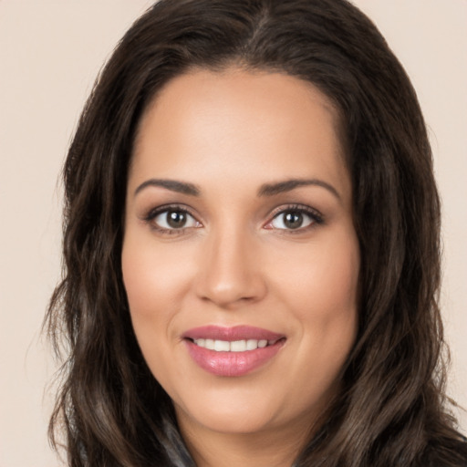 Joyful white young-adult female with long  brown hair and brown eyes