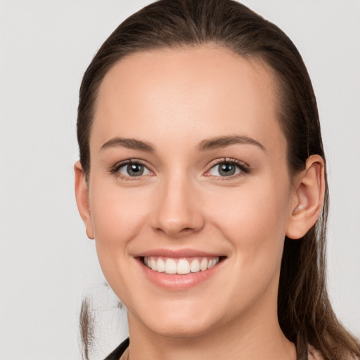 Joyful white young-adult female with long  brown hair and grey eyes