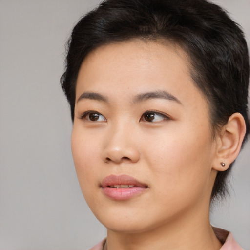 Joyful asian young-adult female with medium  brown hair and brown eyes