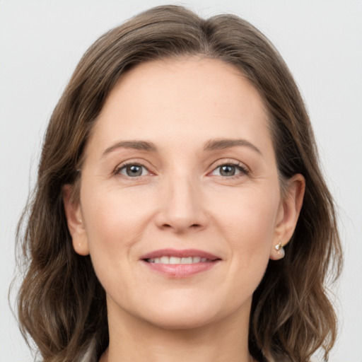 Joyful white young-adult female with medium  brown hair and grey eyes