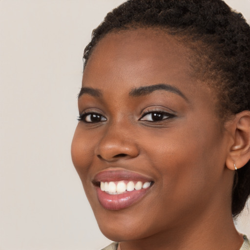 Joyful black young-adult female with medium  brown hair and brown eyes