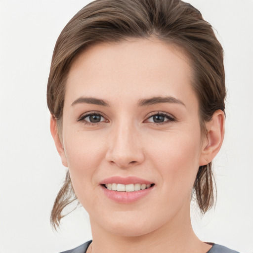 Joyful white young-adult female with medium  brown hair and grey eyes