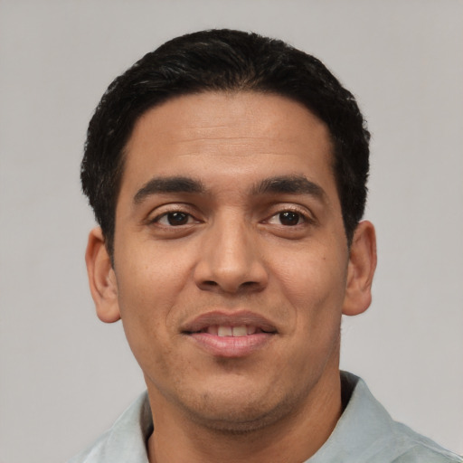 Joyful latino young-adult male with short  black hair and brown eyes