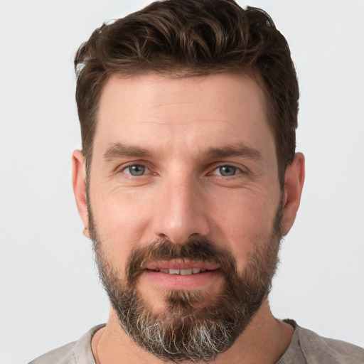 Joyful white adult male with short  brown hair and grey eyes