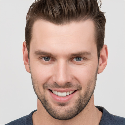 Joyful white young-adult male with short  brown hair and grey eyes