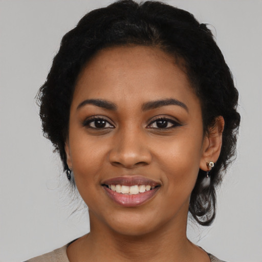 Joyful black young-adult female with medium  black hair and brown eyes
