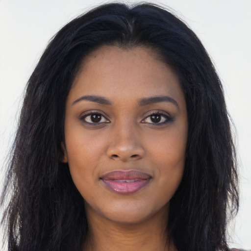 Joyful black young-adult female with long  black hair and brown eyes