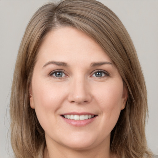 Joyful white young-adult female with long  brown hair and brown eyes