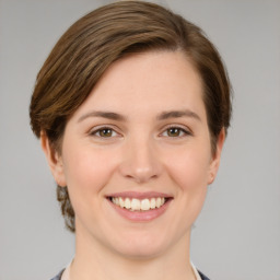 Joyful white young-adult female with medium  brown hair and grey eyes