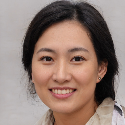 Joyful asian young-adult female with medium  brown hair and brown eyes