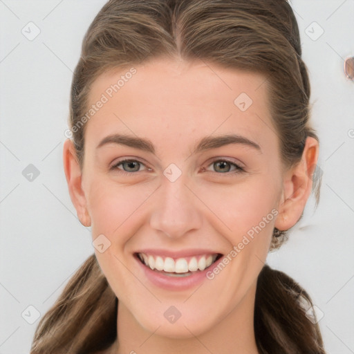 Joyful white young-adult female with long  brown hair and blue eyes