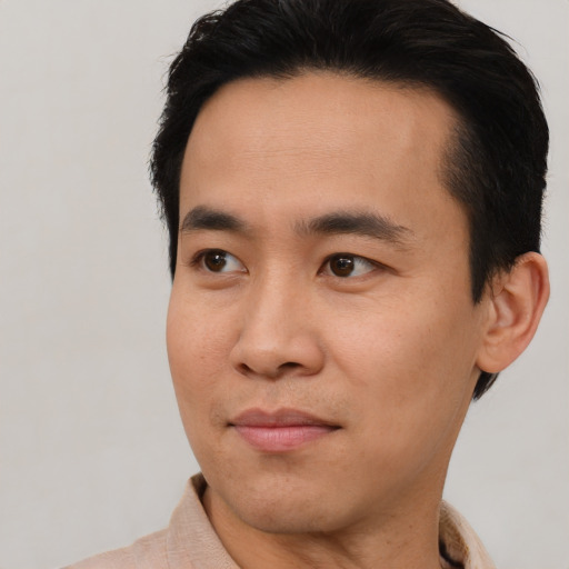 Joyful asian young-adult male with short  brown hair and brown eyes