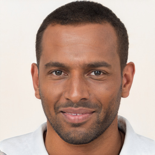 Joyful black young-adult male with short  brown hair and brown eyes