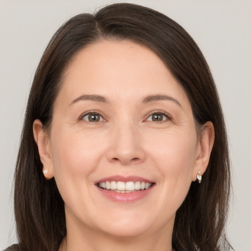 Joyful white adult female with medium  brown hair and brown eyes