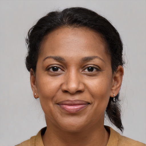 Joyful black adult female with medium  brown hair and brown eyes