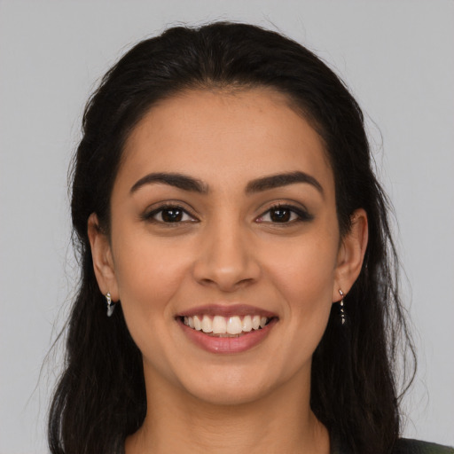 Joyful latino young-adult female with long  brown hair and brown eyes