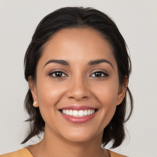 Joyful latino young-adult female with long  brown hair and brown eyes