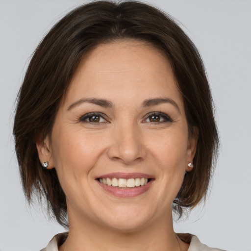 Joyful white adult female with medium  brown hair and brown eyes