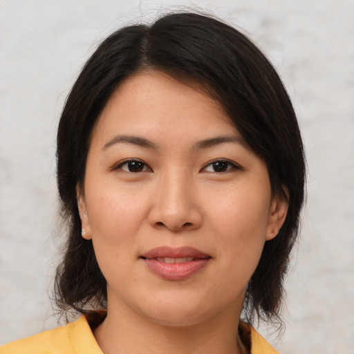 Joyful asian young-adult female with medium  brown hair and brown eyes