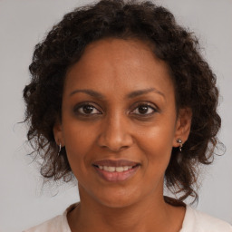 Joyful black adult female with medium  brown hair and brown eyes